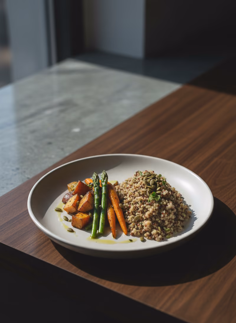 A simply plated catering lunch of vegetables and grains on pale ceramic.